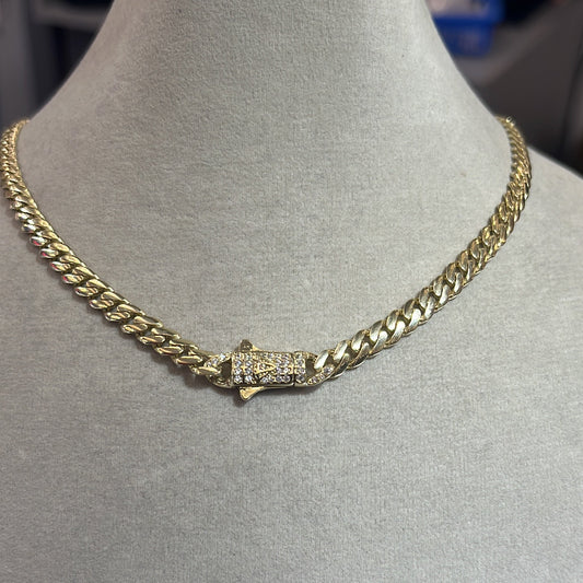 A gold-colored metal chain necklace displayed on a mannequin bust.